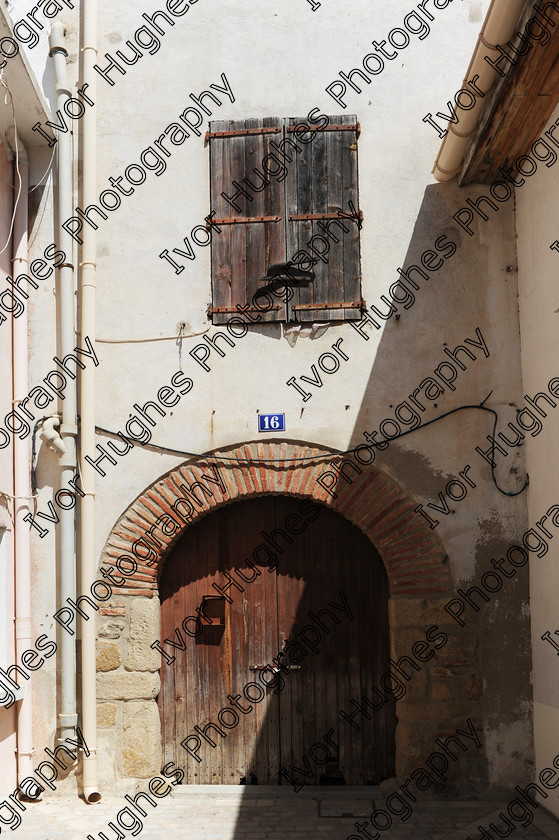 D3N 7609 
 Keywords: Elne Illiberis town village images Languedoc Roussillon 66 France Pyrenees ancient capital city French building street road traffic direction shop signs attention house number 16 sixteen barn door shutters